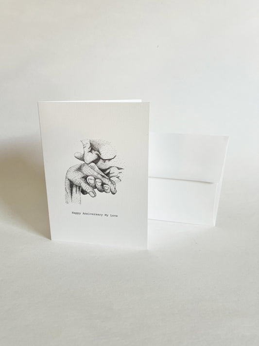 Greeting card with black and white illustration of a hand holding where a man is kissing a women's hand on a white background