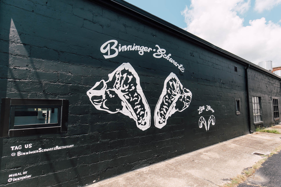Black wall with white graphic design and text on a sunny day