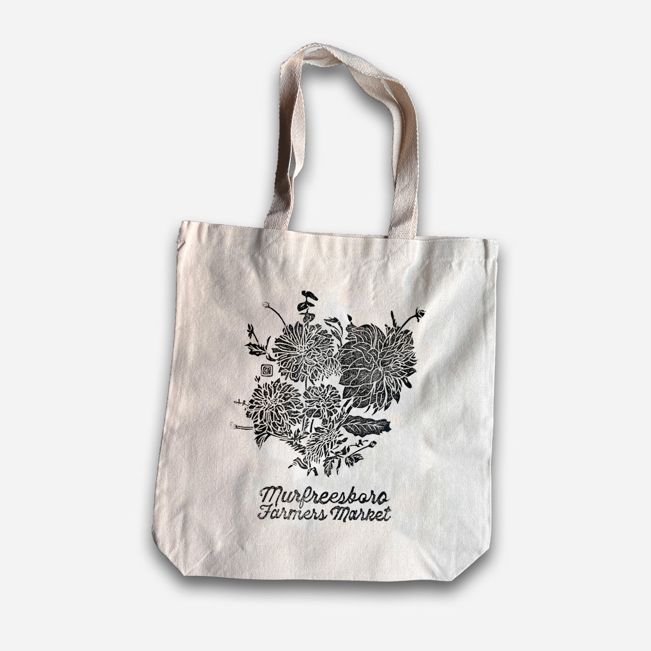 Tote bag with floral design and text on a white background