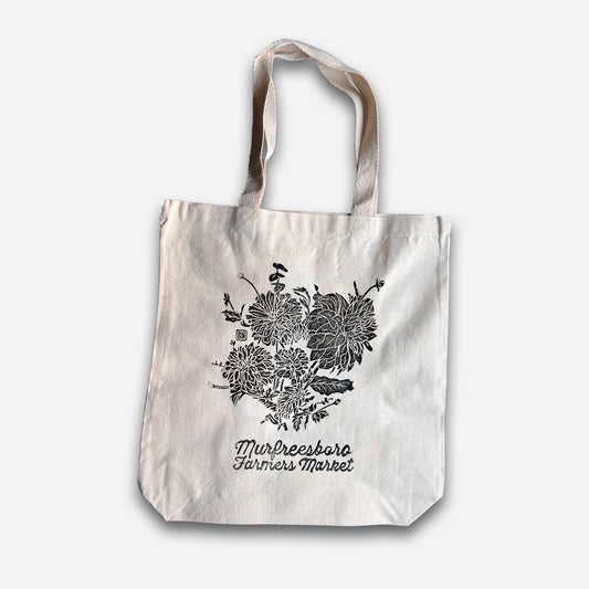 Tote bag with floral design and text on a white background