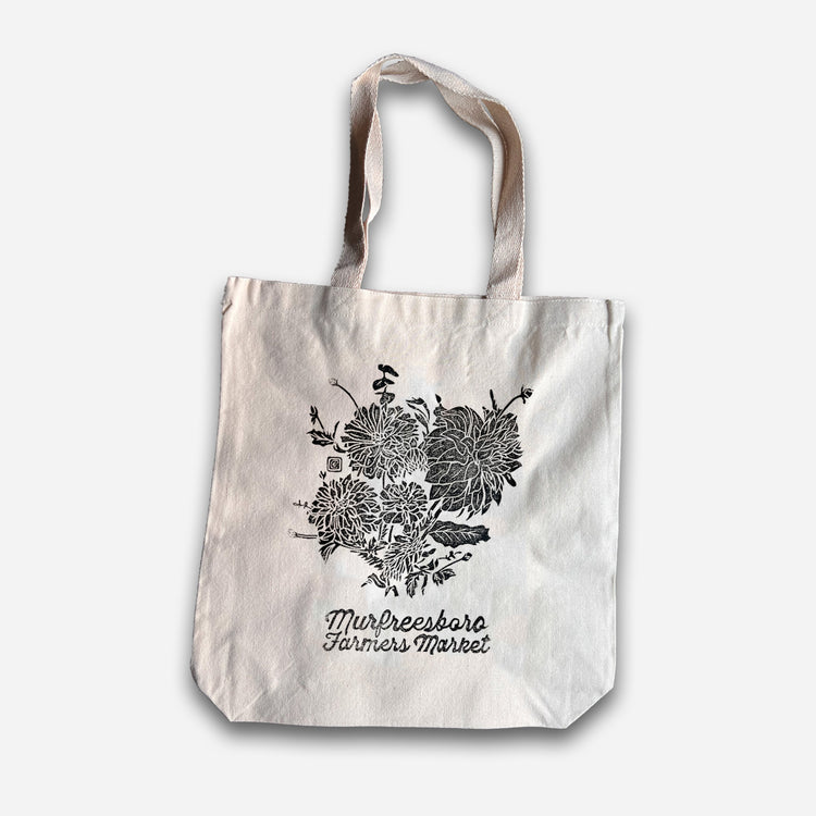Tote bag with floral design and text on a white background