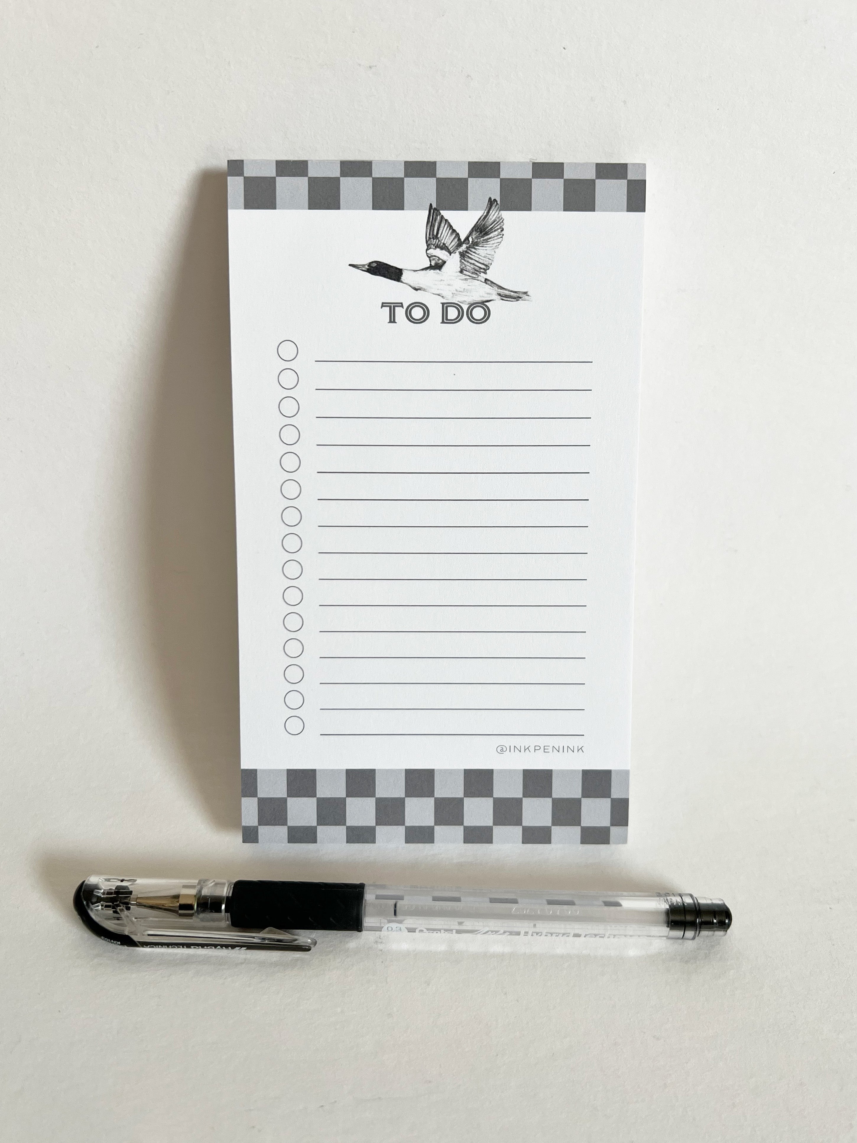 Checkered notepad with 'To Do' list and pen on a white background