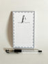 Notepad with 'Just a Note' text and penguin illustration, accompanied by a pen on a light background